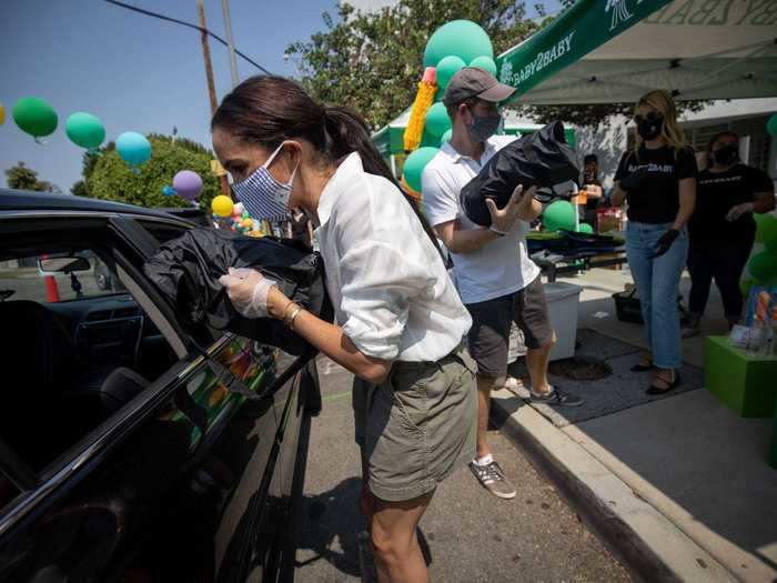 Later in the day, she swept her hair back into a loose ponytail. Prince Harry also kept his outfit California-friendly with a pair of shorts and a gray baseball cap.