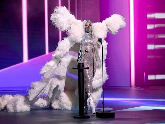 Gaga accepted the artist of the year award in a dramatic Valentino coat with a silver bodysuit from the same designer, white platform boots, and a Mety Choa mask to match.