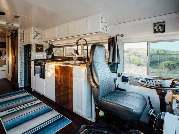 The kitchen features both a stove and oven despite its small size, as well as a full-size refrigerator and custom-made wooden countertops.