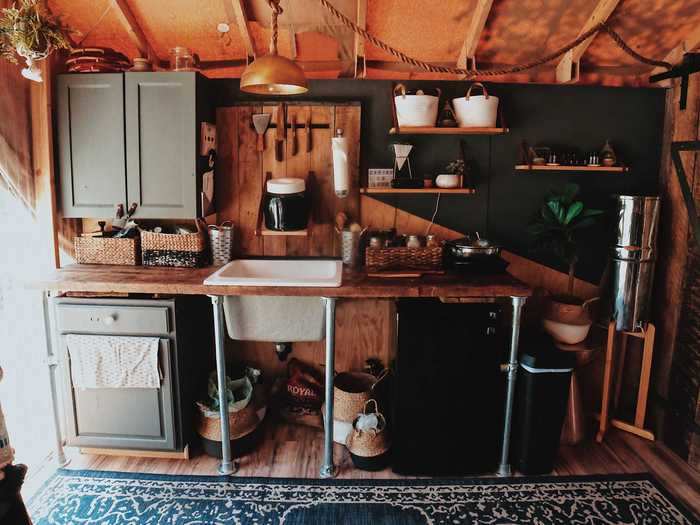 The kitchen takes up one wall of the home, and it features a small burner and mini-fridge.