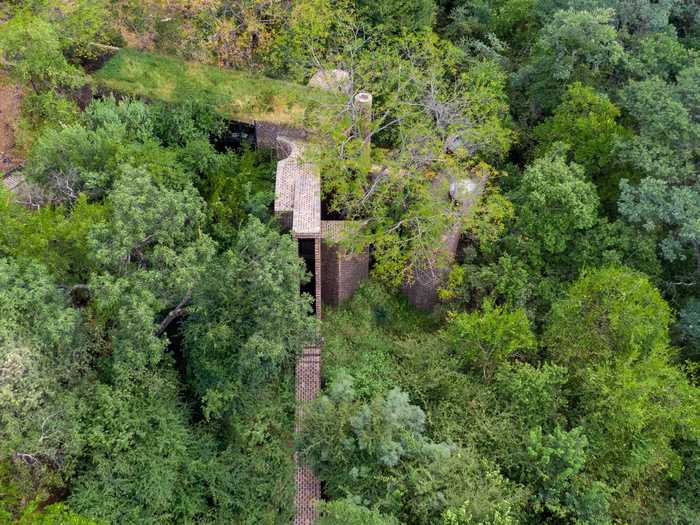 This narrow off-grid home was built in a tree canopy of a South African nature reserve.