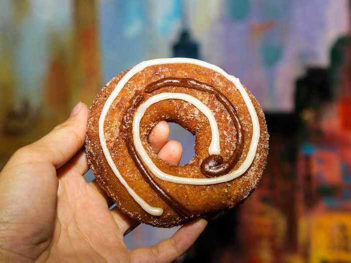 The new Krispy Kreme donut this year is the pumpkin spice cinnamon roll donut: a pumpkin donut dusted with pumpkin spice sugar and topped with swirls of cinnamon and cream cheese frosting.