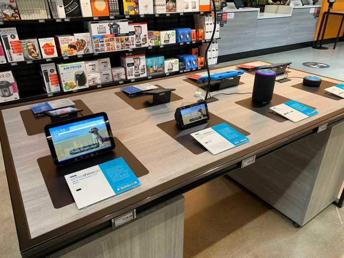 A display table advertises Amazon devices, including tablets and smart speakers.