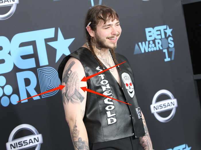 Malone has a tattoo of praying hands holding a gun on his bicep.