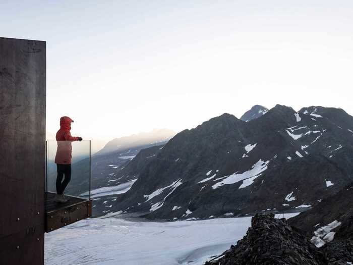 Emerging from the funnel, travelers can step out onto a deck with a glass railing.