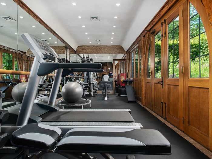 The home gym includes weights, a treadmill, exercise ball, and other equipment.