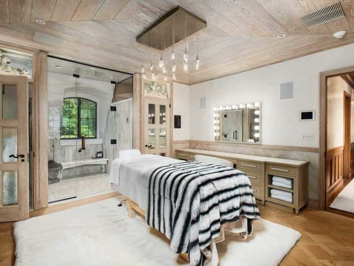 The listing photos show a glamorous master bathroom with a massage table ...