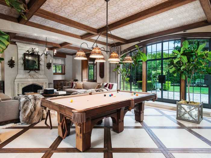 One room is fashioned as an entertainment area, with a billiards table and seating clustered around a fireplace.