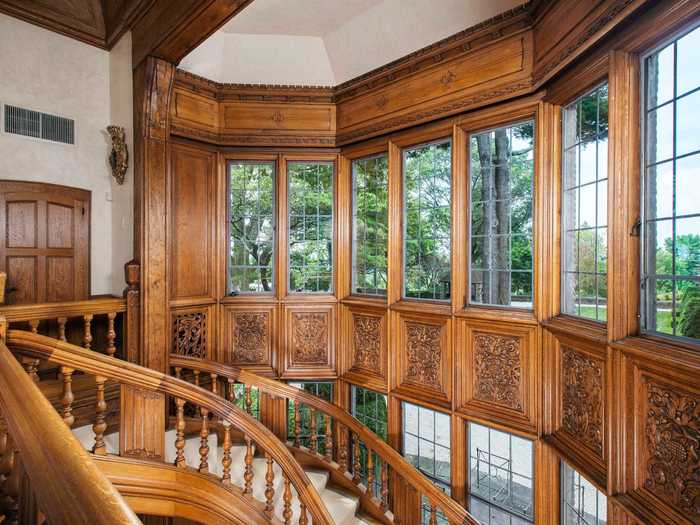 In the reception space, an Elizabethan-style staircase spirals upward in a bay surrounded by windows.