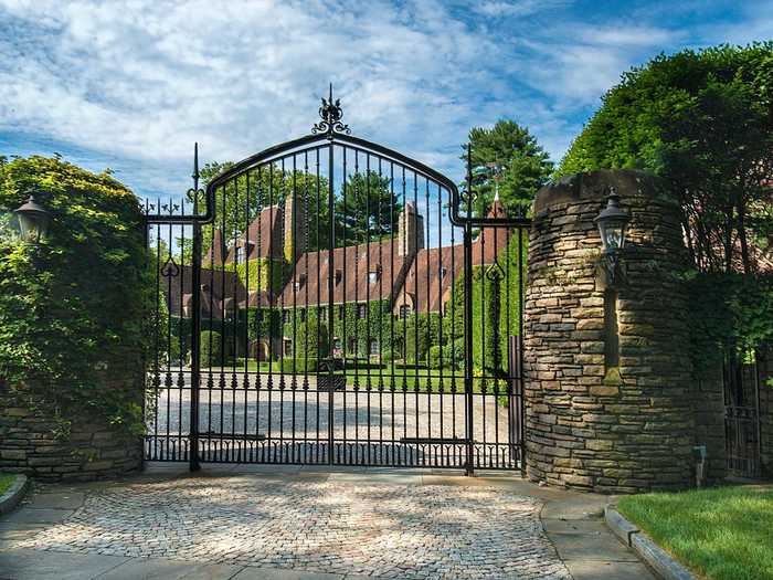 A long driveway and a gated entrance lead to the estate