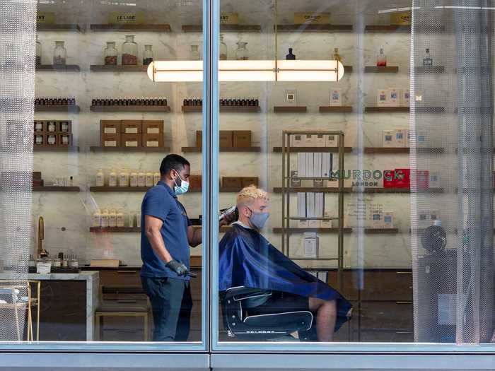 A customer gets their hair cut in a New York City barbershop on July 17.