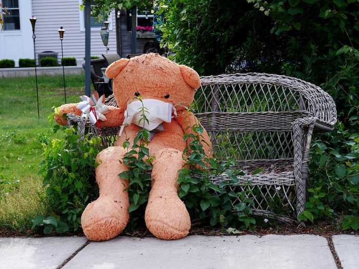 A stuffed bear wearing a mask hangs out on a bench in Winchester, Massachusetts on June 1.