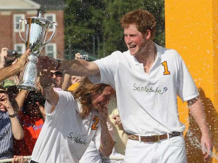 AGE 24: The Prince is sprayed with Champagne by a Sentebale teammate after they triumphed over the Blackwatch team during the 2009 Veuve Clicquot Manhattan Polo Classic on May 30, 2009 on Governor