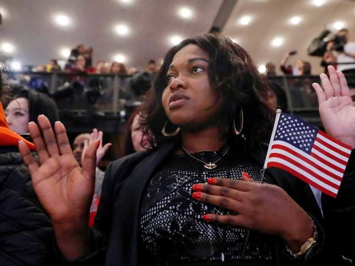 A woman in New York clutches her American flag as she recites the pledge.