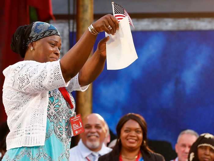 Hatoumata Tounkara, a Muslim refugee who came to the US from Mali, holds up her naturalization certificate.