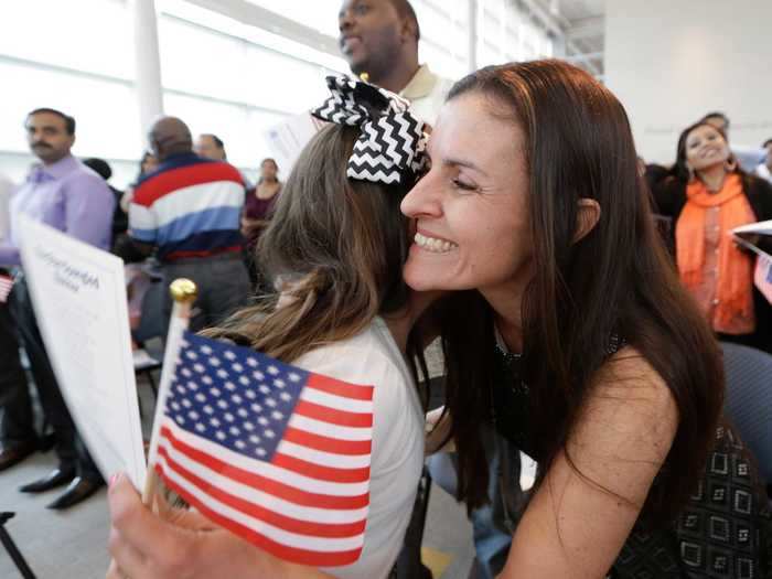 Roberta Minke hugs her daughter Sophia after becoming a citizen.