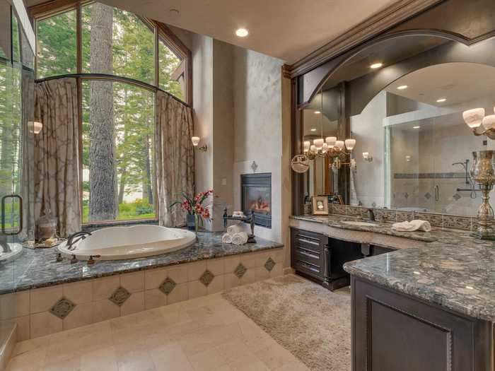 The master bathroom features a large soaking tub, also with views of the outdoors.