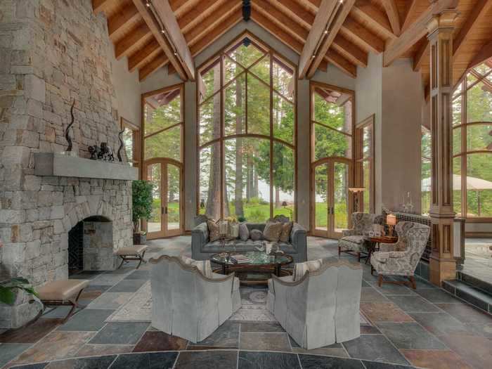 The great room features vaulted ceilings and floor-to-ceiling windows. The home also boasts four fireplaces.