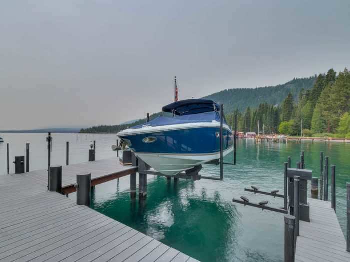 The lakefront home comes with a marina-style pier with a 12,000-pound boat hoist, a jet ski lift, and two boat slips.