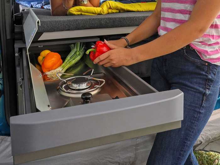 The kitchen can only be used when the trunk lid is lifted, allowing the lid to double as a rain cover while cooking.