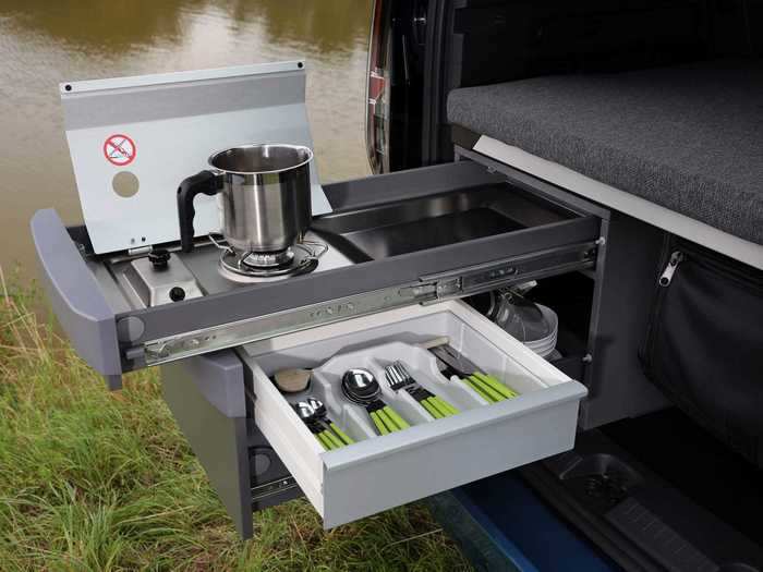 The top half of the kitchen unit has a gas cooktop with a shelf and wind block, while the bottom has storage for cutlery and utensils.