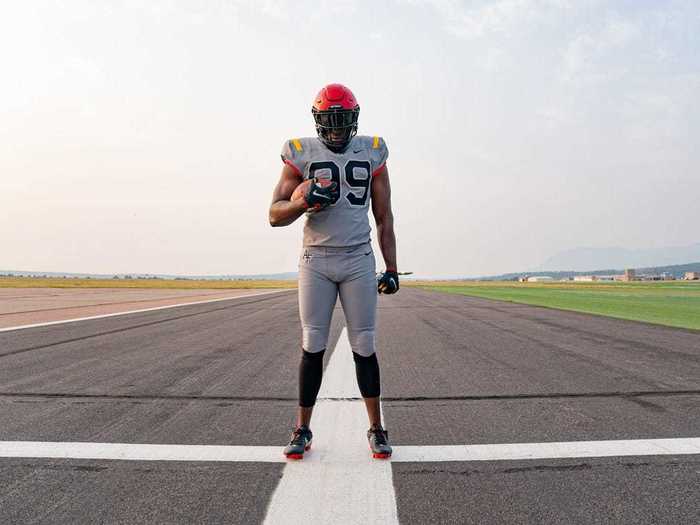 The uniforms are grey with black lettering. The yellow stripes on the shoulders mirror the wings of the P-51 Mustang.