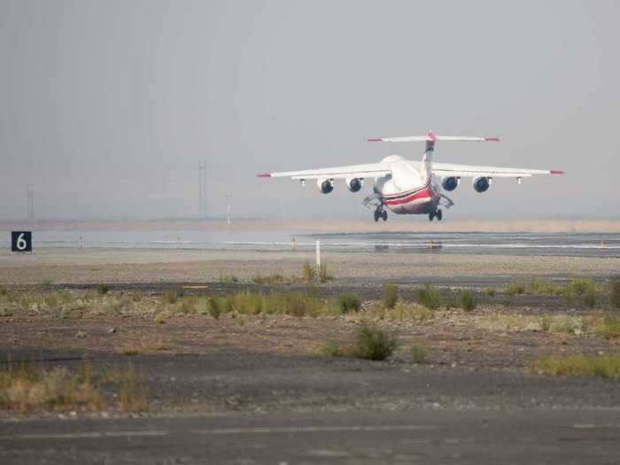 Filled with retardant and a fresh load of fuel, the jet lumbers long down the runway before lifting off and turning eastward toward its target.