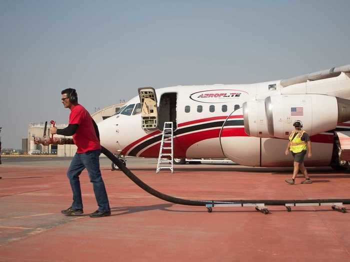 A team of two runs the retardant hose out to the plane, attaching it to the port and loading in some 3,000 gallons into its tanks.