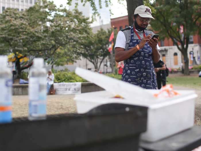 Louisville resident Aaron Johnson stands next to his grill in Jefferson Square Park before handing out food.