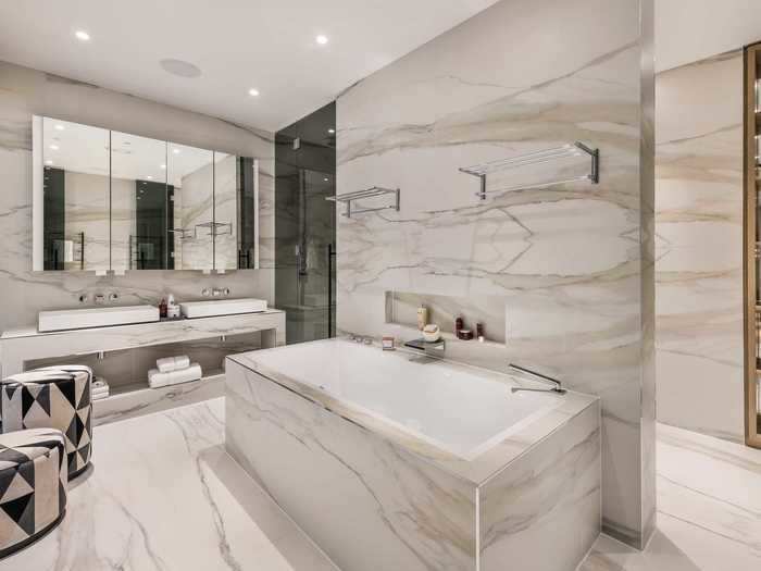 Its white marble en-suite bathroom features a luxurious soaking tub ...