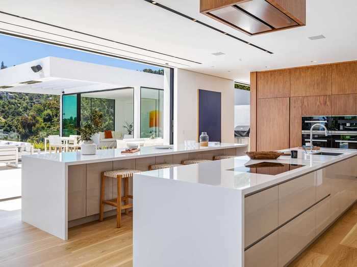 The kitchen comes stocked with two massive islands and upscale Miele appliances. It has marble walls and stainless steel drawers. The house has both a formal dining room and a more lowkey family room.