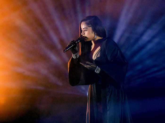 Ella Mai wore a long black robe and gloves that sparkled with diamond bracelets as she took the microphone.