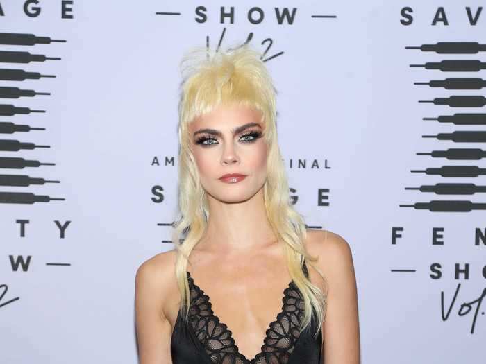 Cara Delevinge wore what appeared to be a blonde mullet wig, a black teddy with a plunging neckline, and high-waisted pants.
