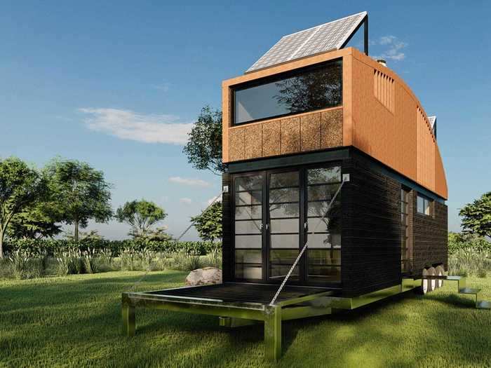 The front of the tiny home consists of a large glass wall and door that leads into the outdoor deck.