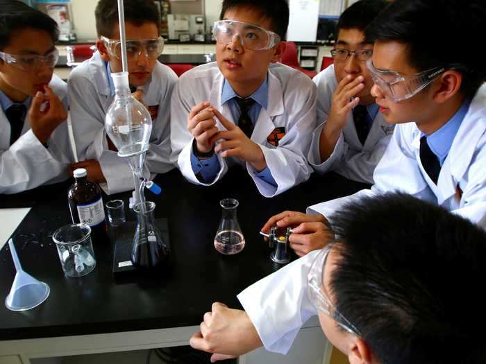 A group of chemistry students studied their equipment at Sydney Grammar School in Australia.