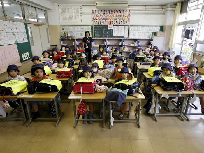 First-grade students and their teacher, Teruko Takakusaki, posed for a photo during their homeroom period in Tokyo, Japan.