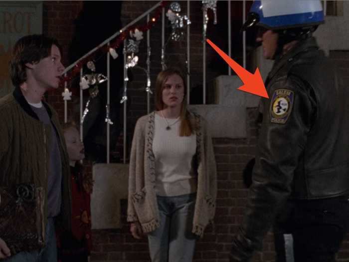 The "cop" that Max, Dani, and Allison run into is wearing a Salem witch badge.