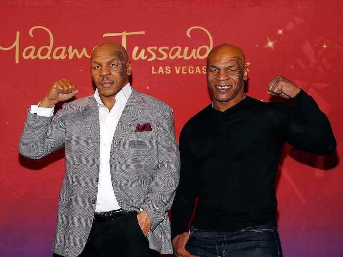 Former boxer Mike Tyson showed off his muscles next to his wax figure.