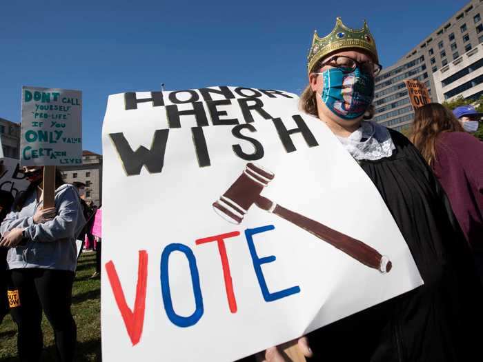 One protester carried a sign that called for Americans to vote and for lawmakers to hold off on selecting a Supreme Court justice to replace Ginsburg.