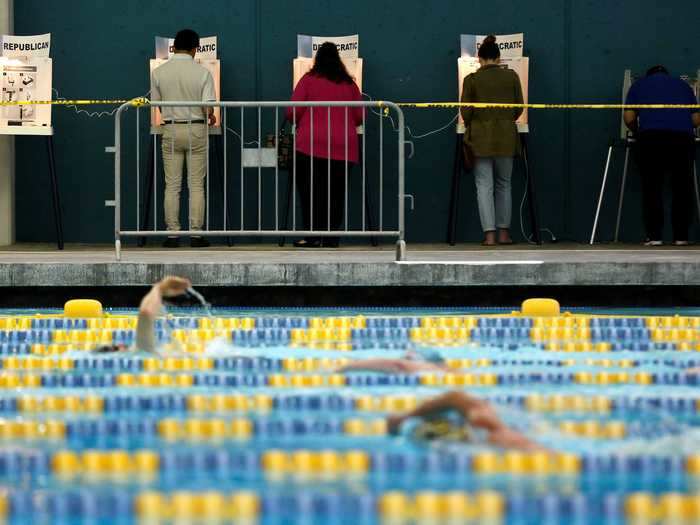 Voters cast their ballots in the 2016 presidential primary as swimmers completed laps in the Echo Park Deep Pool in Los Angeles, California.