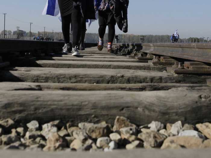 An American man visiting the former Auschwitz-Birkenau death camp in Poland was charged with attempting to steal a piece of the historic train tracks.