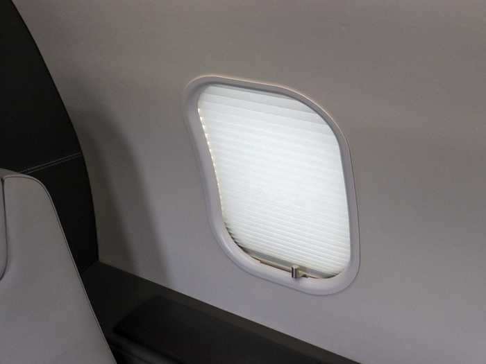 Instead of the traditional airline-style pull-down window shade, a metallic slider controls the shade.