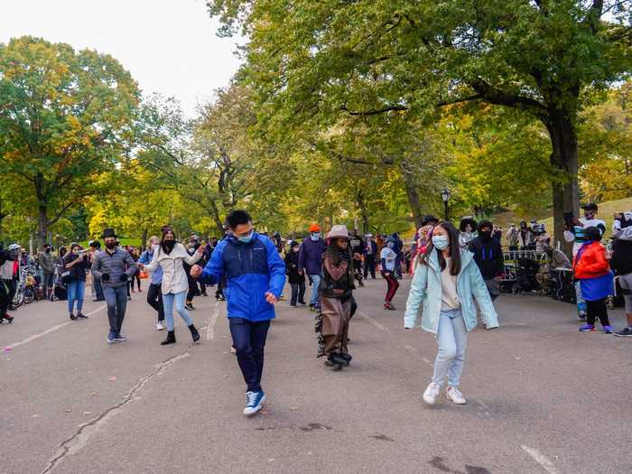 Several people in face masks, costumed or not, danced to upbeat electronic music.