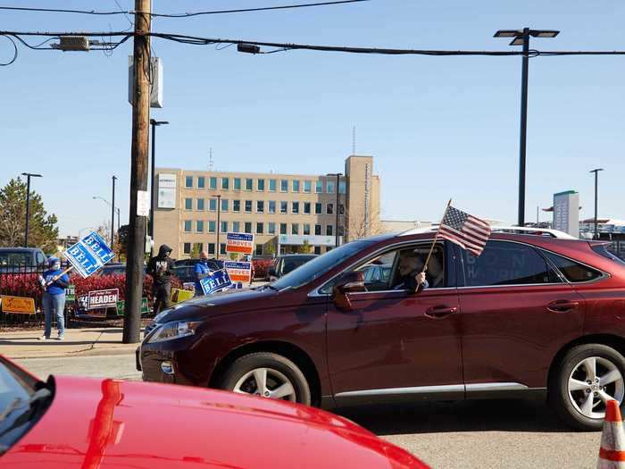 A driver waves an American flag out of their car window outside the Board of Elections in Cleveland, Ohio, on October 31, 2020.