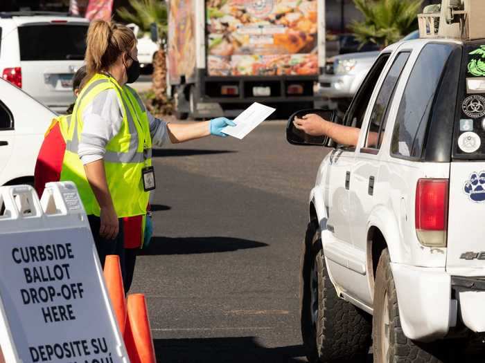 Arizonians vote at a drive-thru ballot drop-off at Recorders East Side Annex in Tucson on October 30, 2020.