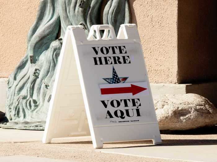 A "vote here" sign is displayed outside Kirk-Bear Canyon Library in Tucson on October 30, 2020.