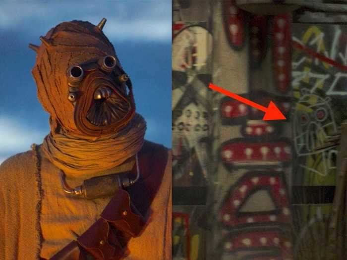 In the opening scene, part of the graffiti looks like a Tusken Raider, AKA one of the Sand People with whom the Mandalorian teams up with later.