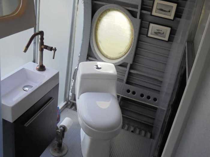 The bathroom is located inside the plane with a toilet and shower.