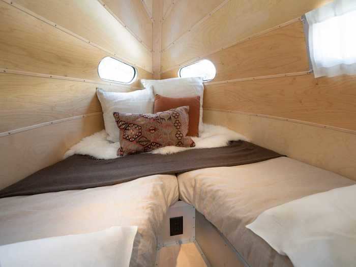 Moving on, the bedroom at the rear of the trailer comes with a nightstand, reading lights, and two twin beds that can convert into a king bed.