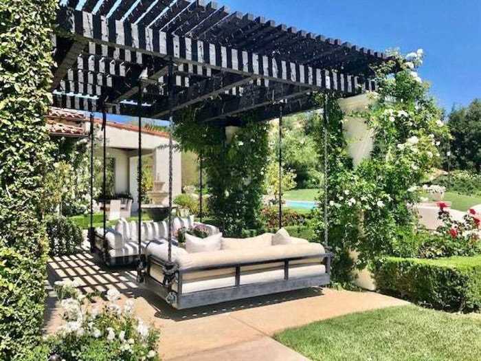 The outdoor space includes a yard with several spots to relax, including these swinging couches ...